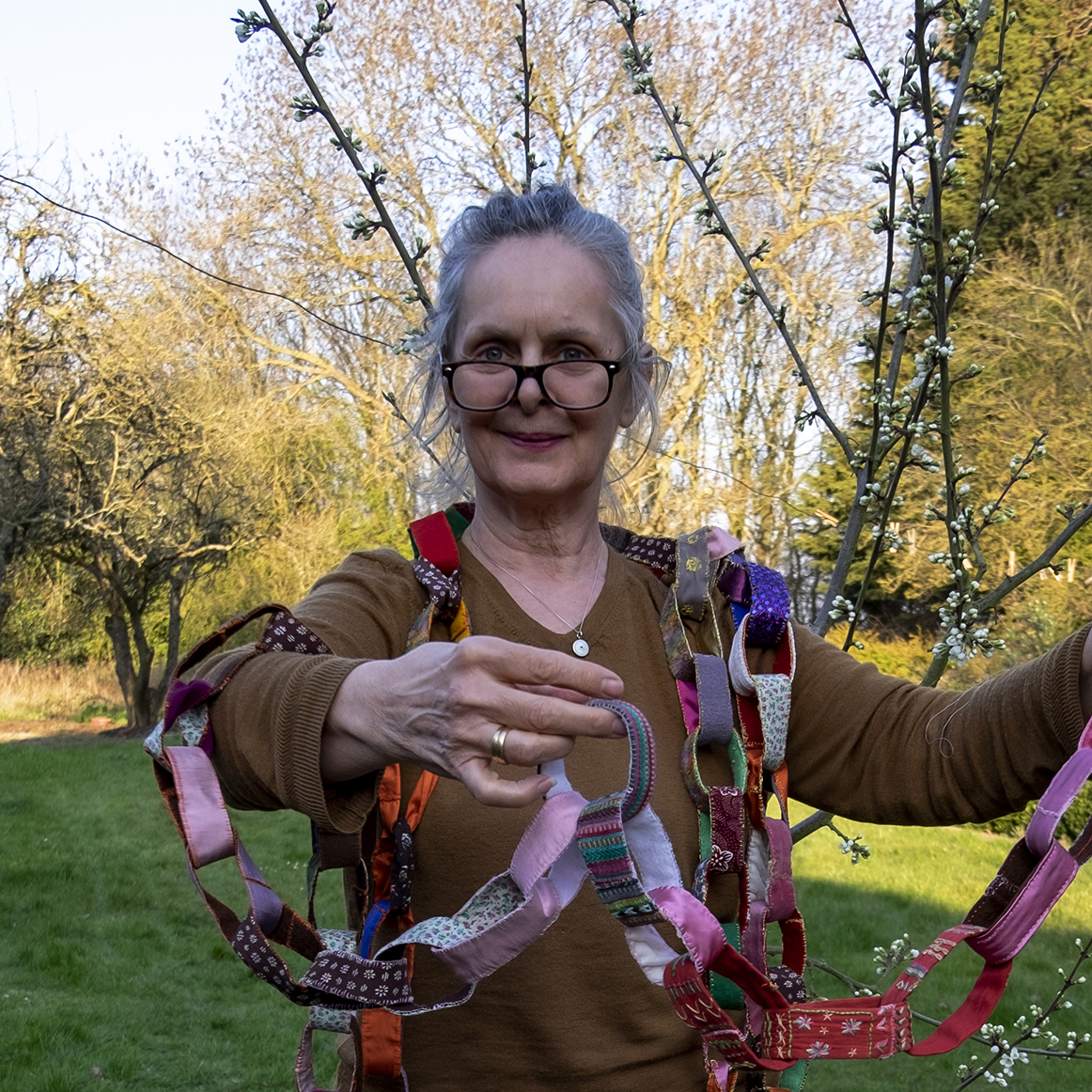 a picture of artist Jane Glynn wrapped around colourful paper chains